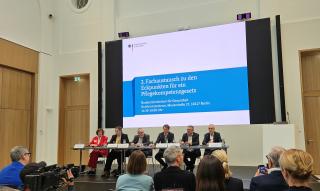 Podium mit 6 Personen, u.a. Bundesgesundheitsminister Lauterbach