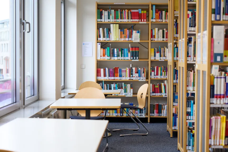 Einige leere Tische und Stühle in einer Bibliothek